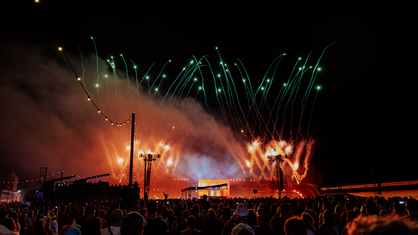 Zu sehen in die Bühne des Glücksgefühle Festivals während der Closing Show. Es schießt riesiges Feuerwerk in die Luft. Tausende Menschen schauen der Show zu.